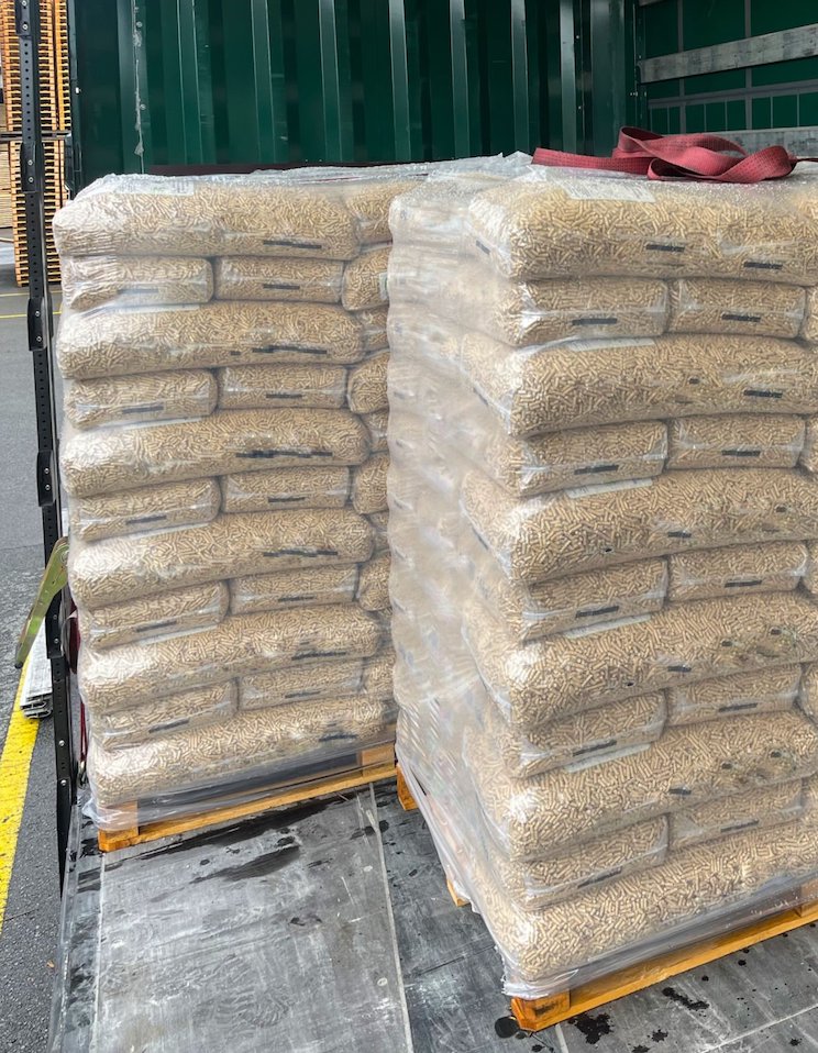 Packed wood pellets on pallets loaded into a semi-trailer for transportation.