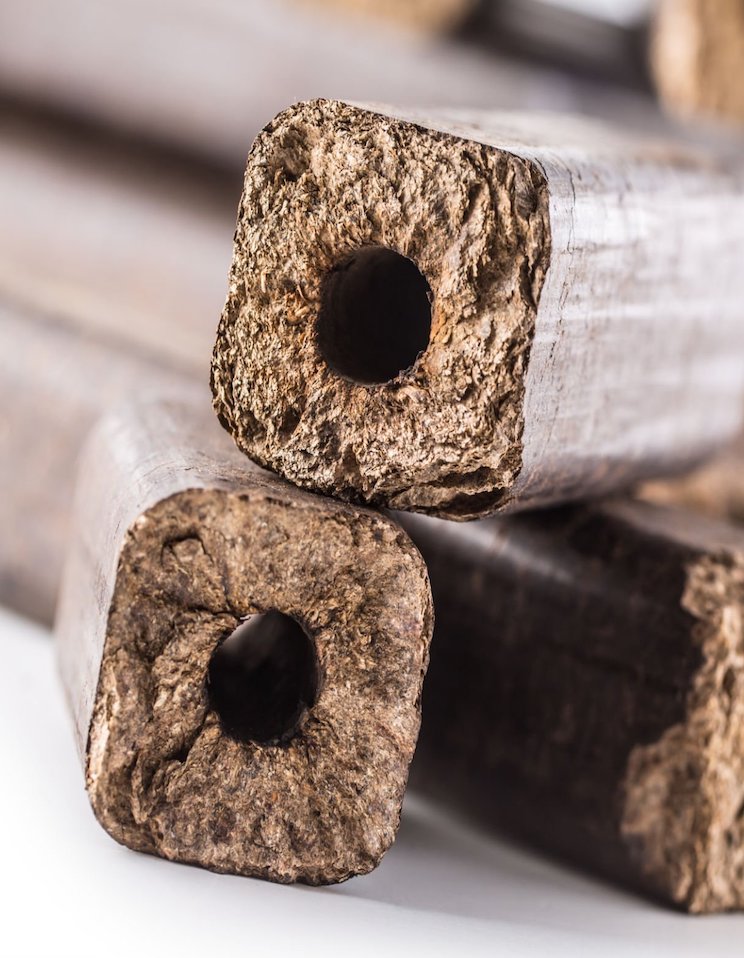 Wooden pressed briquettes Pini Kay from biomass on a white isolated background.